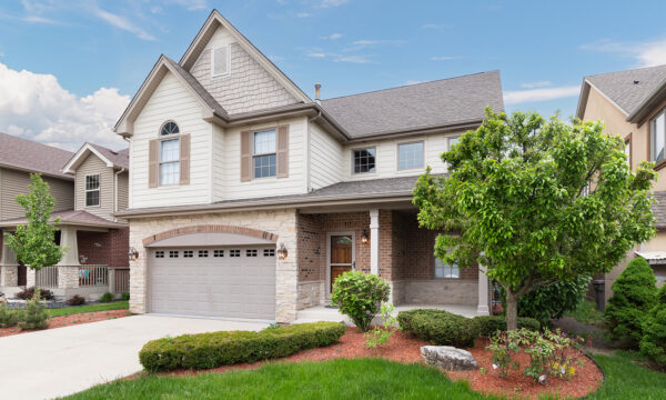 Orland,Park,,Il,,Usa,-,May,20,,2019:,A,New ORLAND PARK, IL, USA - MAY 20, 2019: A new suburban house with half light brown siding and have brick and stone, brown window shutters, and a front porch.